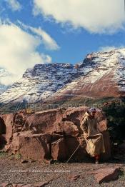 Image du Maroc Professionnelle de  Un berger berbère du haut Atlas vêtu par son djellaba colorée presque de la teinte de la pierre, s'incruste dans les roches de montagnes, comme un caméléon à proximité de l'Oukaimden, Samedi 22 Février 1987. (Photo / Abdeljalil Bounhar)